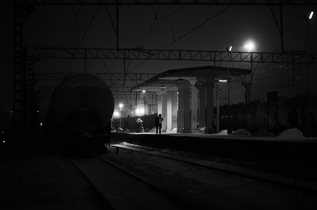 Old train station platform at night with fog and a single light