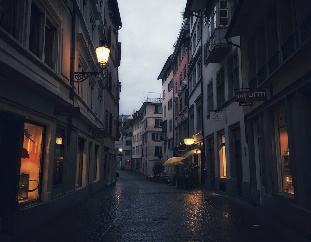 Quiet empty street in a small Central European town at night with rain